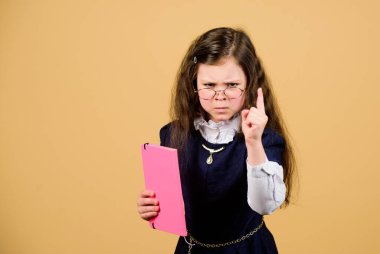 Bilgi ve eğitim. Okula dönelim. Ev ödevi. Kağıt klasörlü küçük bir kız. Gerçekten küçük bir kız öğretmen olmak istiyor. Günlük notları için not defteri. Ders çalışmak. Sınava odaklanmış. Boşluğu kopyala