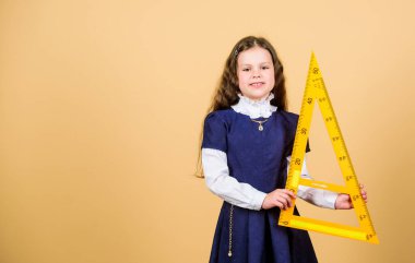 Çocuk okulu üniforması cetveli tutar. Matematiği severim. Eğitim ve okul konsepti. Zekice ve zekice bir fikir. Boyut ve boyut. Büyük cetveli olan tatlı bir öğrenci. Okul öğrencisi geometri okuyor.