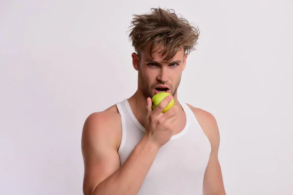 L'atleta con i capelli disordinati morde la frutta fresca. Alimentazione e salute — Foto Stock