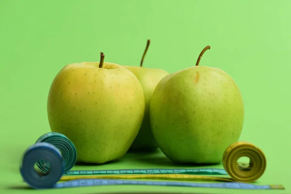 Deportes y símbolos de estilo de vida saludable. Manzanas cerca de cintas métricas laminadas —  Fotos de Stock