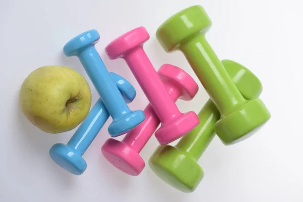 Hälso- och träningssymboler. Hantlar nära grönt äpple — Stockfoto