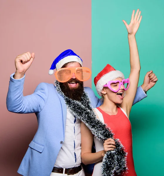 Christmas party office. Corporate holiday party ideas. Winter corporate party. Office christmas party. Happy man and woman wear santa hats and funny sunglasses. Manager tinsel celebrate new year