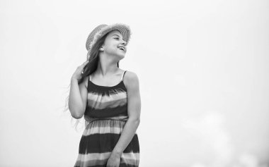 Rahatlamanın tadını çıkarıyorum. Çocuk mutlu küçük kız. Özgür ve kaygısız. İyi titreşimler. Uluslararası çocuk bayramınız kutlu olsun. Yaz elbise ve şapka açık havada gökyüzü arka plan sevimli kız. Mutlu tatiller. Mutlu çocukluk