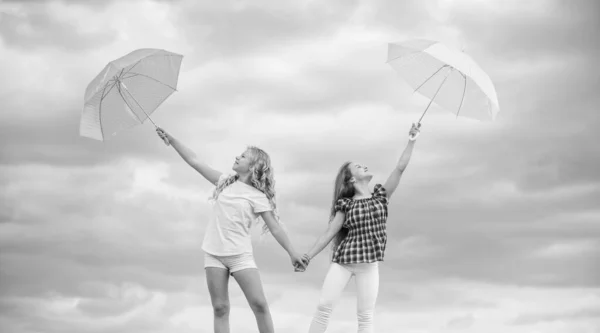 날씨에 대비하는 거지. 소녀들은 구름낀 하늘 배경을 가진 우산을 가지고 친구가 된다. 일기 예보. 날씨 변화. 야외에는 태평 한 아이들이 있다. 바람 이 오든 비가 오든 우리는 준비가 되어 있습니다. 자유와 신선 함 — 스톡 사진