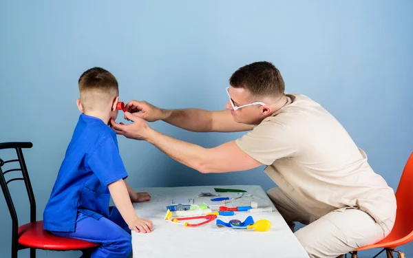 Medicina y salud. niño feliz con padre con estetoscopio. Un niño pequeño con papá jugando. Carrera futura. padre e hijo en uniforme médico. Asistente de laboratorio de enfermería. médico de familia. doctos asistente — Foto de Stock