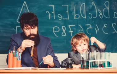 Kimya sınıfındaki göz bebeği karizması. Okula dönelim. Baba ve oğul okulda. Bilim kimyası konsepti. Sakallı öğretmen ve küçük çocuk. Eğitim doğuştan gelen bir haktır.