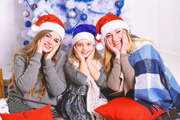 Family or friends in Santa hats near present boxes — Stock Photo, Image