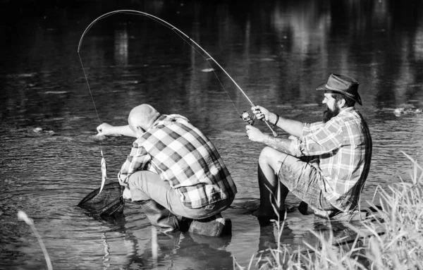 fly fish hobby of men. retirement fishery. retired father and mature bearded son. Two male friends fishing together. happy fishermen friendship. big game fishing. relax on nature. Ready for fishing