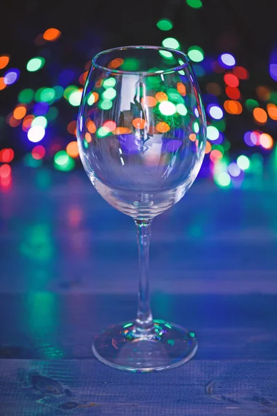 Alcohol cocktail for winter party. Cocktail ideas concept. Easy recipes for winter alcoholic cocktail drinks. Cocktail glass on defocused garland colorful lights. What to drink on christmas party