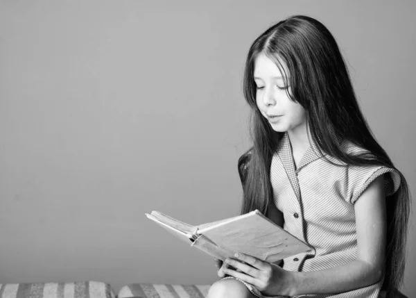 Bedårande Bookworm. Söt liten barnbok läsning på violett bakgrund. Liten flicka lära sig läsa. Hemundervisning koncept. Törst av kunskap. Läsa litteratur som hobby. Skönlitteratur och fakta — Stockfoto