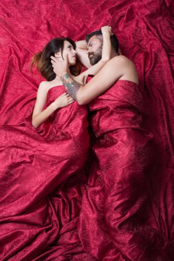 Sakallı bir adam yatakta güzel bir bayana dokunuyor.