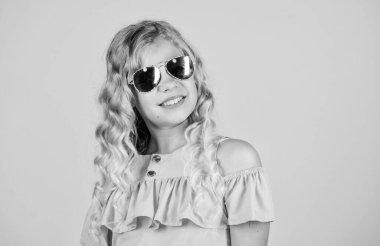 Optik mağazası. Güneş gözlüğü yaz aksesuarı. Yaz trendi. Küçük moda. Sevimli küçük çocuk moda kız. Kız uzun kıvırcık saç güneş gözlüğü giymek. Uv koruması. Göz sağlığı. Uygun güneş gözlüğü satın alın