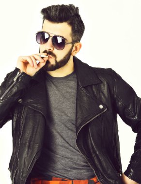 Sakallı adam, bıyıklı beyaz hippi sigara içiyor.