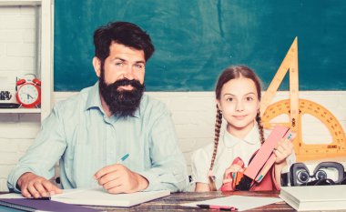 bilgi günü. Evde eğitim. özel ders. sınıfta sakallı öğretmen adam ile küçük kız çocuk. baba ile kızı çalışma. Öğretmenler günü. Okula geri dön. Özel öğretmenlik. Çok çalışmak