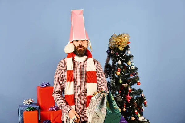 Comprador com pacote rosa na cabeça detém sacos de compras. — Fotografia de Stock