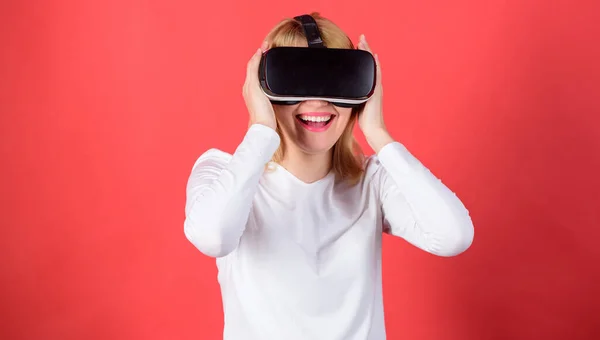 Egy fehér blúzos nő portréja virtuális valóság szemüveggel a fején, vörös háttérrel elszigetelve. Happy woman exploring augmented world, interakció a digitális felület. — Stock Fotó