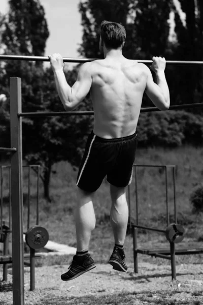Pull ups op sportveld gedaan door atleet met spieren — Stockfoto