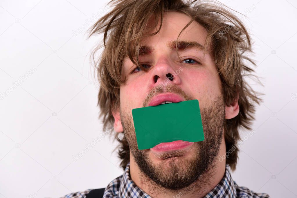 Man holds dark green card in mouth.