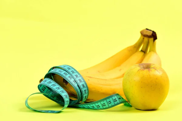Tape voor meten, bos van bananen en rijpe appel, — Stockfoto