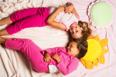 Pembe battaniye arka plan üzerinde mutlu yüzler çocuklarla yakın yalan.