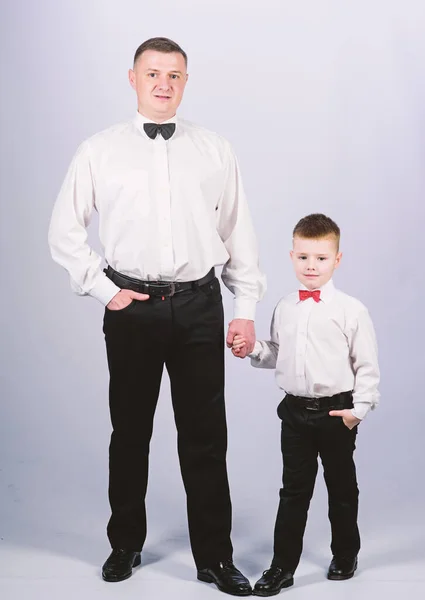 La educación de los caballeros. Hijo pequeño siguiendo el ejemplo de los padres de un hombre noble. La educación de los caballeros. Visita el código de vestimenta del teatro. Traje de ropa formal de padre e hijo. Evento formal. Crecer caballero — Foto de Stock