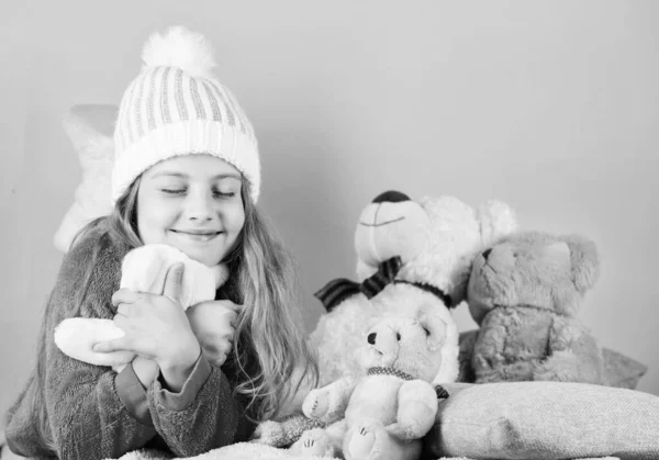 Дитяча маленька дівчинка грайливо тримає плюшеву іграшку ведмедя. Маленька дівчинка грає з м'якою іграшкою плюшевого ведмедя на рожевому тлі. Колекція іграшок ведмедів. Плюшеві ведмеді допомагають дітям впоратися з емоціями і обмежити стрес — стокове фото
