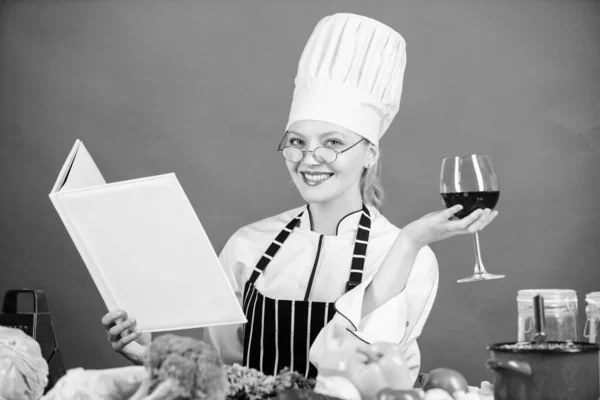 Woman hat and apron study culinary arts. Culinary expert. Chef cooking healthy food. Girl read book best culinary recipes. Culinary school concept. Book by famous chef copy space. Professional level