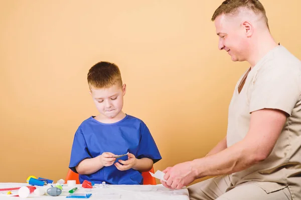 Medical help. Medical insurance. Medicine concept. Kid little doctor sit table medical tools. Health care. Medical examination. Salary of hospital worker. Boy cute child and his father doctor — Stock Photo, Image