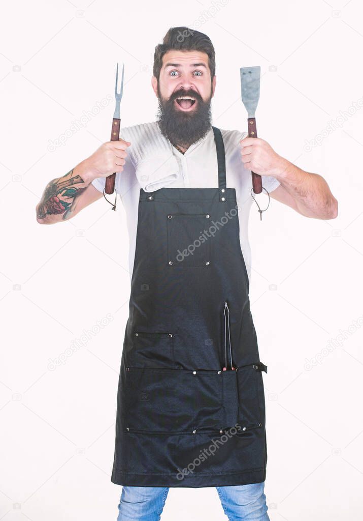 Kitchen utensils for keeping hands far away from heat. Grill cook with fork and spatula cooking utensils in hands. Bearded man holding barbecue utensils. Chef hipster with metal grill utensils