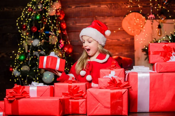 Tomten gav mig presenter. Barnglad upphetsad flicka hitta gåvor nära julgran. Lycka och glädje. God jul, då. Glad barndomsidé. Grabben bär tomte hatt hålla insvept jul presentförpackning — Stockfoto