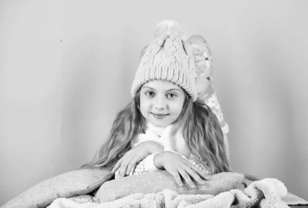 Девочка носит вязаную шляпу расслабляющий розовый фон. Ребенок длинные волосы теплые шерстяные шляпы пользуются теплым. Концепция теплой одежды. Будьте в тепле и комфорте. Теплые аксессуары, которые будут держать вас уютно этой зимой — стоковое фото