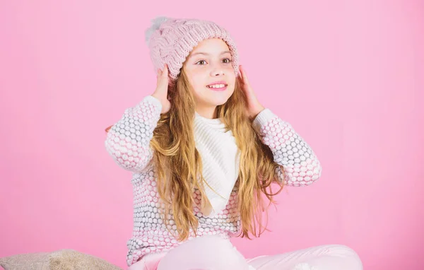 Soft knitted accessory. Tips for caring for knitted garments. Child long hair warm soft woolen hat enjoy softness. Kid girl wear knitted soft hat pink background. Keep knitwear soft after washing — ストック写真