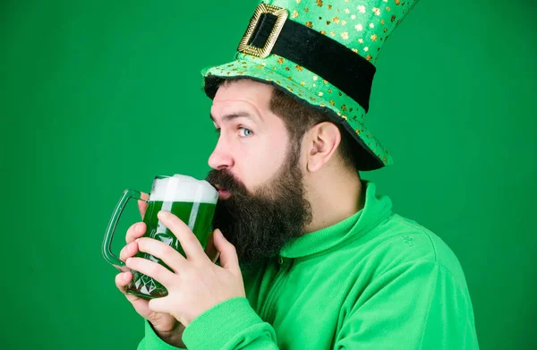 Irish tradition. Man brutal bearded hipster drink beer. Irish pub. Drinking beer part celebration. Bar seasonal holiday menu. Dyed green traditional beer. Alcohol beverage. Lets start patricks party