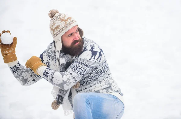 Making snowball. Happiness concept. Smiling man snow background. Snow games. Have fun winter day. Cheerful bearded hipster knitted hat and warm gloves play with snow outdoors. Christmas holidays — Stock Photo, Image