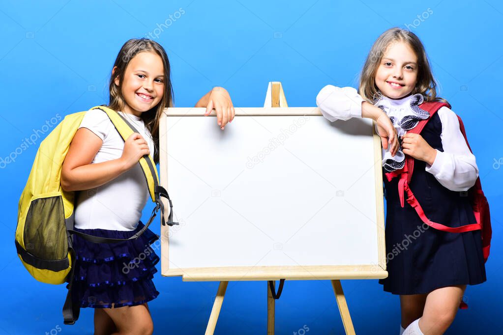 Schoolgirls next to marker board on blue background