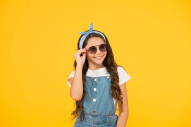 Gözlerini koru. Küçük çocuk klasik güneş gözlüğü. Tatil modu başladı. Küçük moda düşkünü. Çocuk giyim mağazası. Retro kız. Yaz modası. Neşeli küçük kız sarı arka plan. Retro çocuk uzun saç