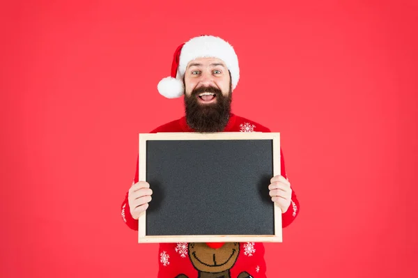 新年のご挨拶です。サンタは大晦日パーティーにあなたを歓迎します。髭の男は空の黒板を持っている。メリークリスマス明けましておめでとうございます。新年の商業広告、コピースペース — ストック写真