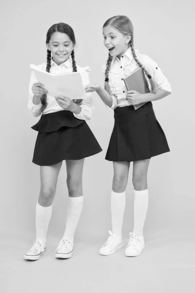 Un ver de bibliothèque. Des petites filles en uniforme scolaire. carnet de dictionnaire. Obtenir des informations. lire l'histoire. littérature pour enfants. Les enfants apprennent la grammaire. retour à l'école. camarades de classe joyeux avec cahier d'exercices — Photo