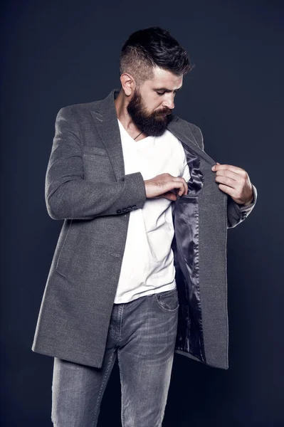 Pocket inside coat. Serious concentrated man. Caucasian man with brutal appearance. Bearded man with moustache and beard on unshaven face in brutal style. Brutal hipster wearing casual outfit