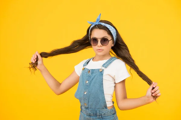 Haare so stark. fröhliches kleines Mädchen gelbe Wand. retro Kind lange Haare. Kleines Mädchen mit Sonnenbrille und Kopftuch. Frohe Sommerferien. UV-Schutz. Sommer-Accessoires. Frühjahrskindermode — Stockfoto