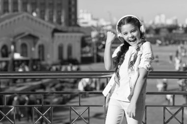 Evet, ben yaptım. Kulaklıklı mutlu küçük kız kazanan hareketi gösteriyor. Küçük bir çocuk stereo ses teknolojisinden hoşlanıyor. Yeni teknoloji. Müziği teknoloji olmadan hayal bile edemezsin. Teknoloji konsepti