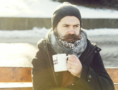 Kaşlarını çatan adam bardaktan içer.