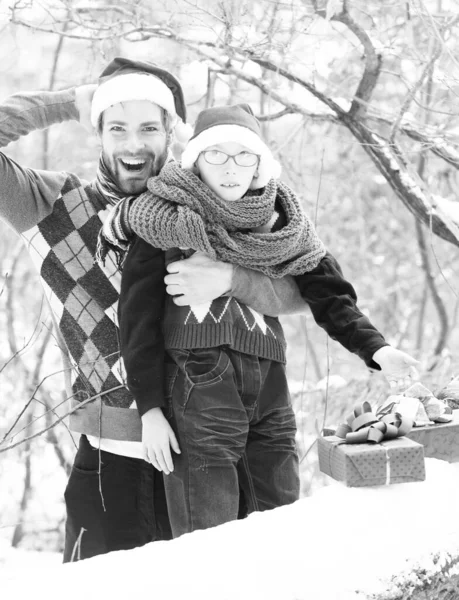 Boże Narodzenie chłopiec i człowiek ojciec z prezentami w zimie na świeżym powietrzu — Zdjęcie stockowe