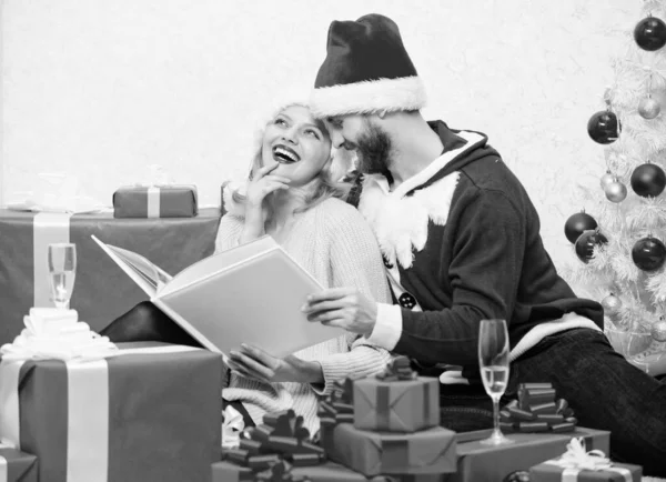 家族の伝統。恋のカップルはクリスマスをお楽しみください。ハッピーフラッシュバック。家族の写真アルバムを見ながら、クリスマスツリーの近くに家族の抱っこ。今年の明るい瞬間を覚えておいてください。一緒に新年を祝う — ストック写真