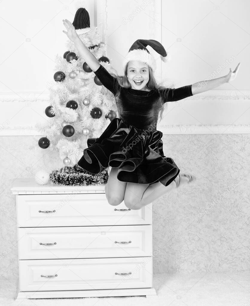 Girl excited about christmas jump mid air. Child emotional cant stop her feelings. Celebrate christmas concept. Girl in dress jumping. It is christmas. Day we have waited for all year finally here
