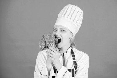 Kadın profesyonel şef çiğ brokoli sebze tutun. Ücretsiz sağlıklı vejetaryen ve vegan yemek tarifleri. Sağlıklı çiğ gıda. Diyet kavramı. Sağlıklı yemek. Kız giyim şapka ve önlük sebze tutun. Sağlıklı rasyon