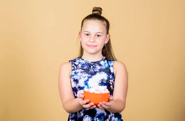 Desafio Marshmallow. Menina sorrindo tigela rosto hold com doce marshmallows na mão bege fundo. Conceito dos dentes doces. Miúda com cabelos longos gosta de doces e guloseimas. Calorias e dieta. Miúdo faminto — Fotografia de Stock