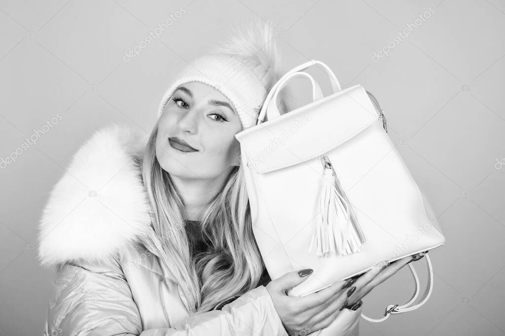 what is inside. girl in puffed coat. faux fur fashion. flu and cold season. Leather bag fashion. warm winter clothing. shopping. happy winter holidays. woman in beanie hat with backpack