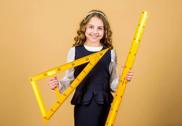 Education and school concept. Smart and clever concept. Sizing and measuring. School student study geometry. Kid school uniform hold ruler. Pupil cute girl with big ruler. Geometry school subject — Stock Photo, Image