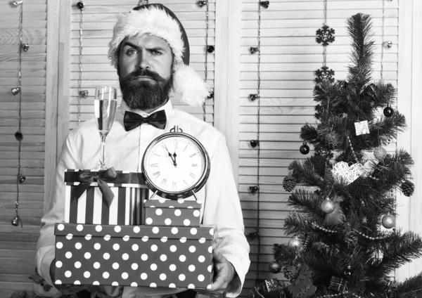 Papai Noel em chapéu com rosto sedutor detém presentes . — Fotografia de Stock